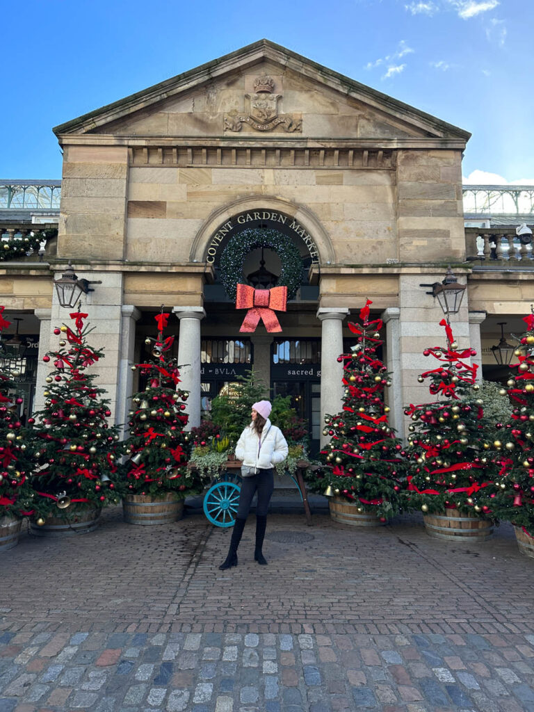 Amy stood in front of Christmas trees in Covent Garden